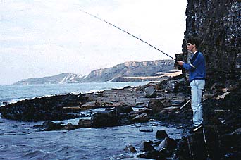 An angler backed up against cliffs by a big spring tide.